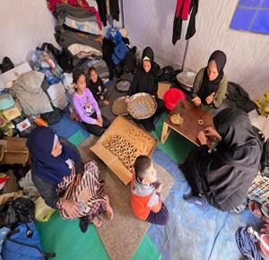 نازحون في خان يونس يُعدّون كعك عيد الفطر التقليدي داخل خيمة مؤقتة وسط نقص الوقود وإغلاق المعابر الحدودية في غزة بسبب العدوان